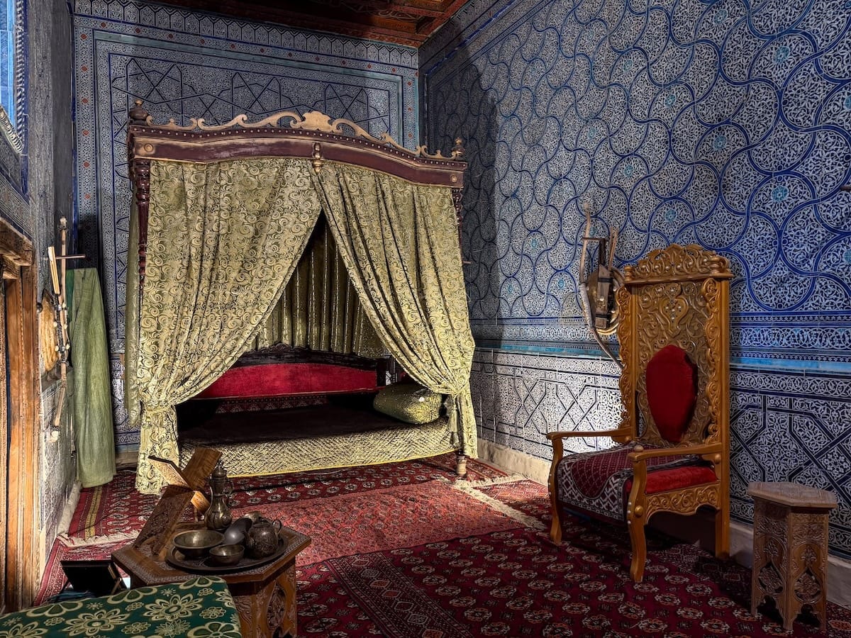 an ornate room with a bed and canopy and a tiled wall