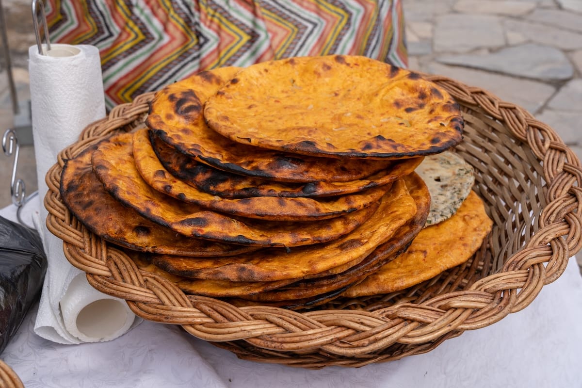 pumpkin orange colored breads on a table in a basket