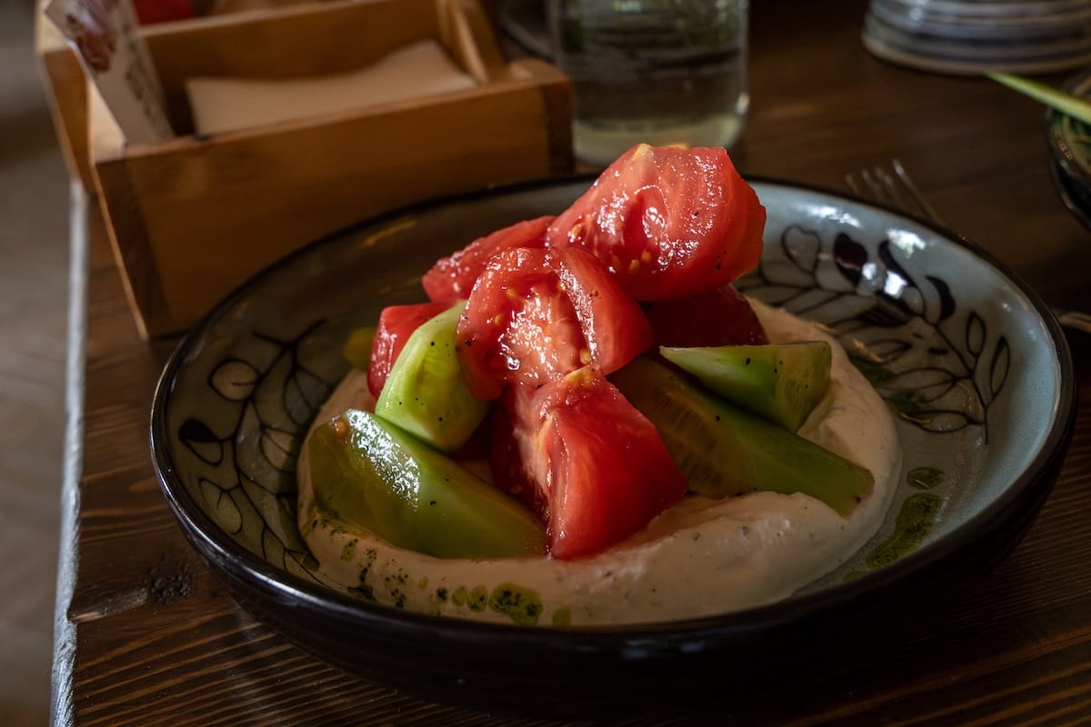 tomatoes and cucumbers in a bowl of yoghurt on a table