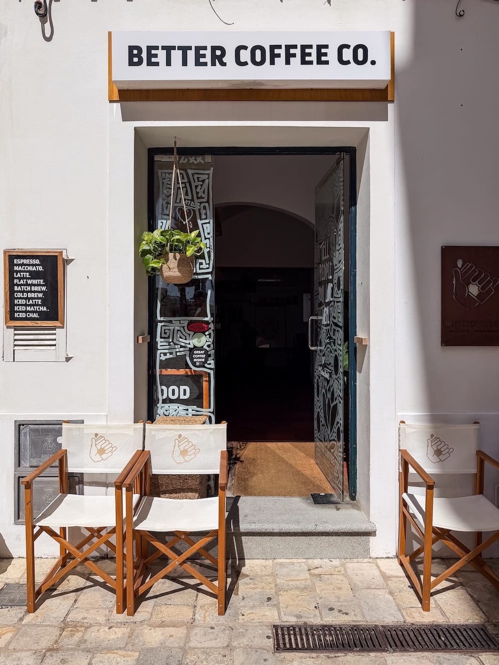 the outside of a specialty coffee cafe with chairs in front of it