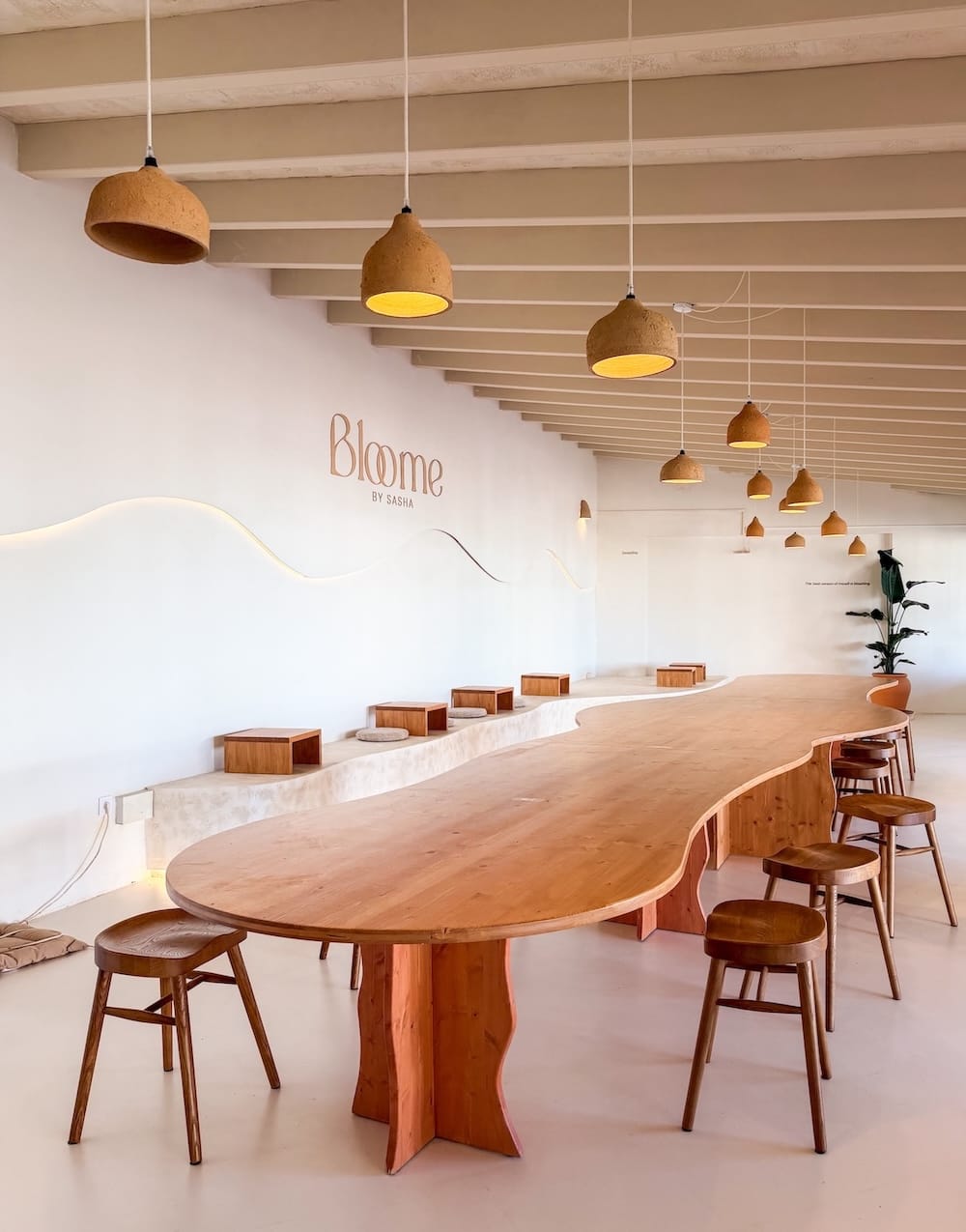 inside a minimalistic coffee shop with a long wooden table and chairs