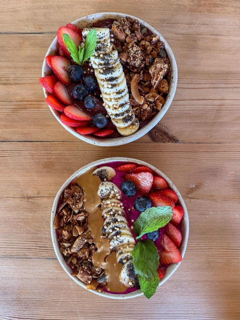 an acai and pitaya bowl on a table with fruit on top