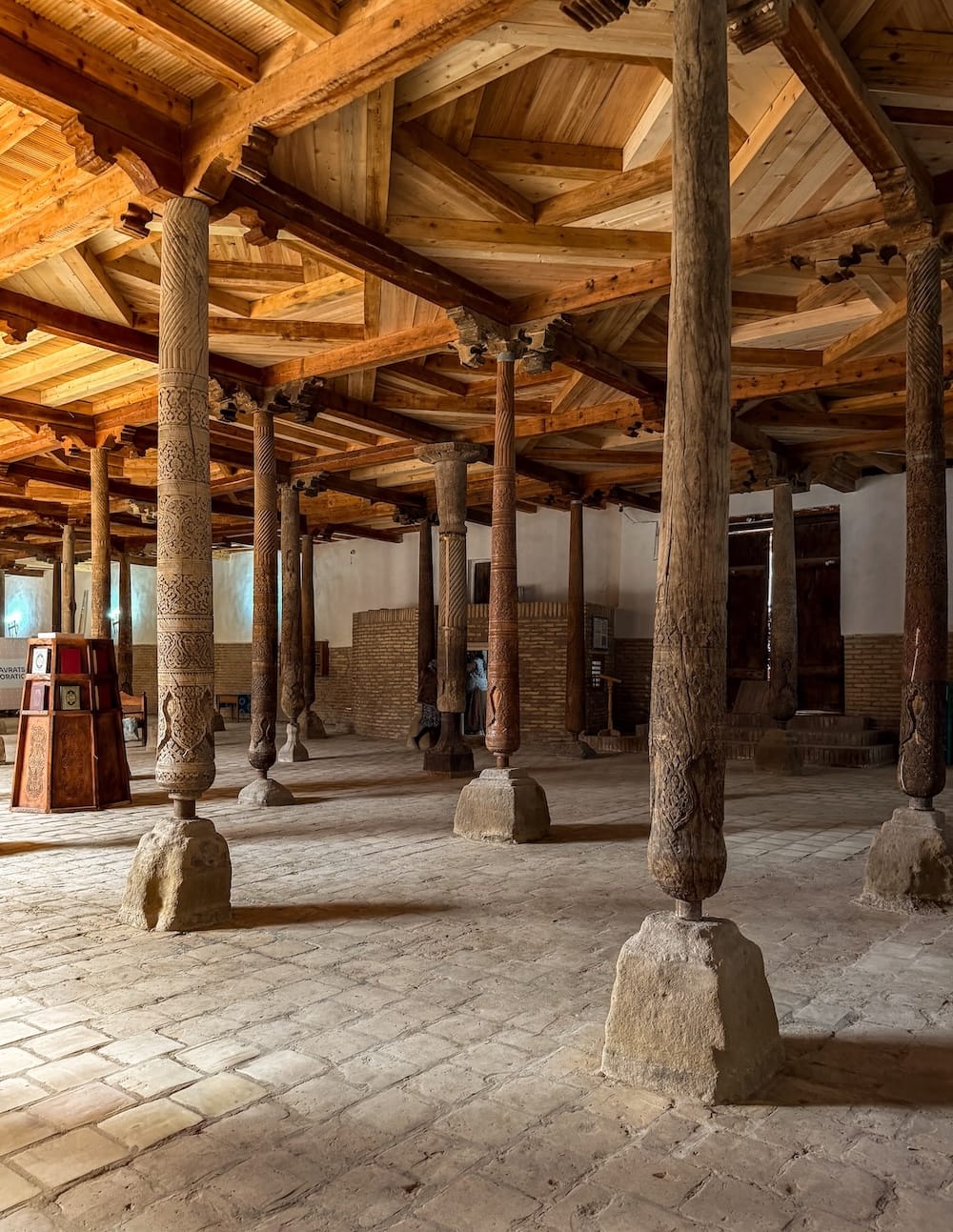 an old mosque with hundreds of wooden pillars with carvings