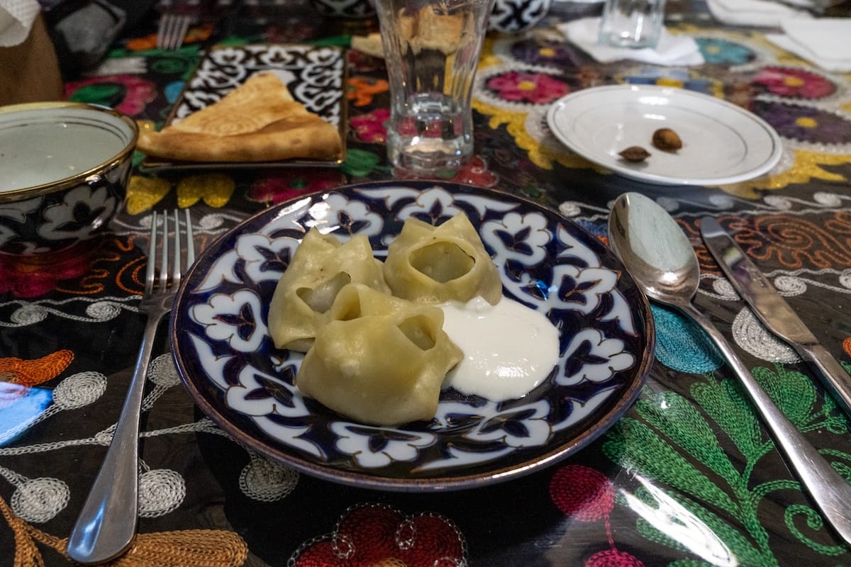 some manti on an uzbek plate with sour cream