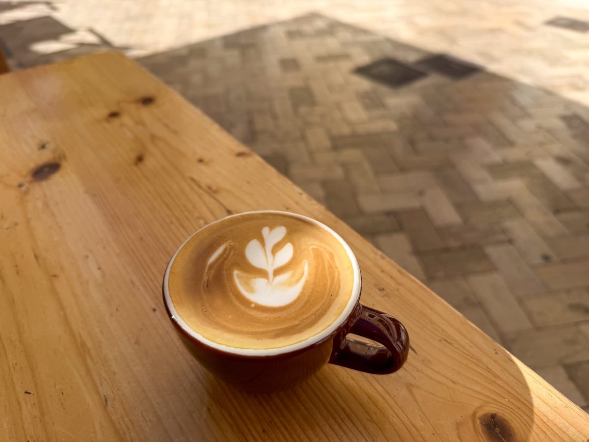 A flat white coffee on a table in a ceramic cup