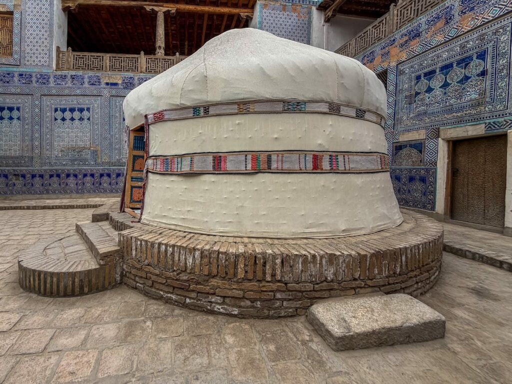 a yurt inside a blue/teal Islamic tiled courtyard in Uzbekistan