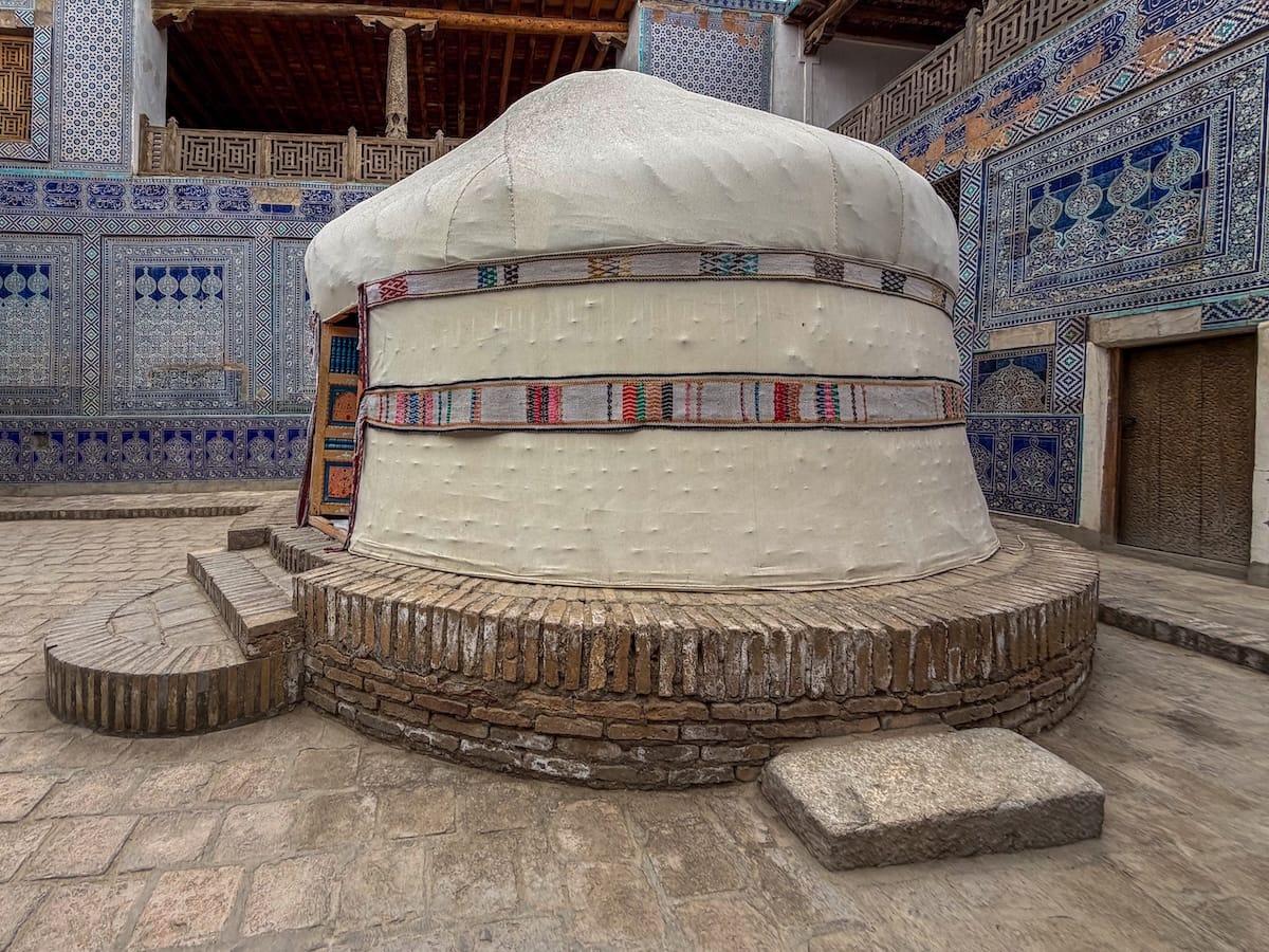 a yurt inside a blue/teal Islamic tiled courtyard in Uzbekistan