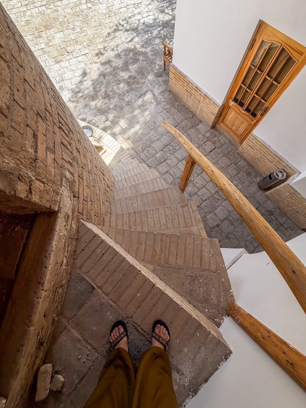 a woman's feet standing on stairs on a minaret in uzbekistan