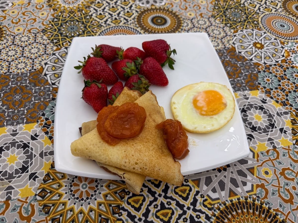 crepes, strawberries, and an egg on a plate at a hotel
