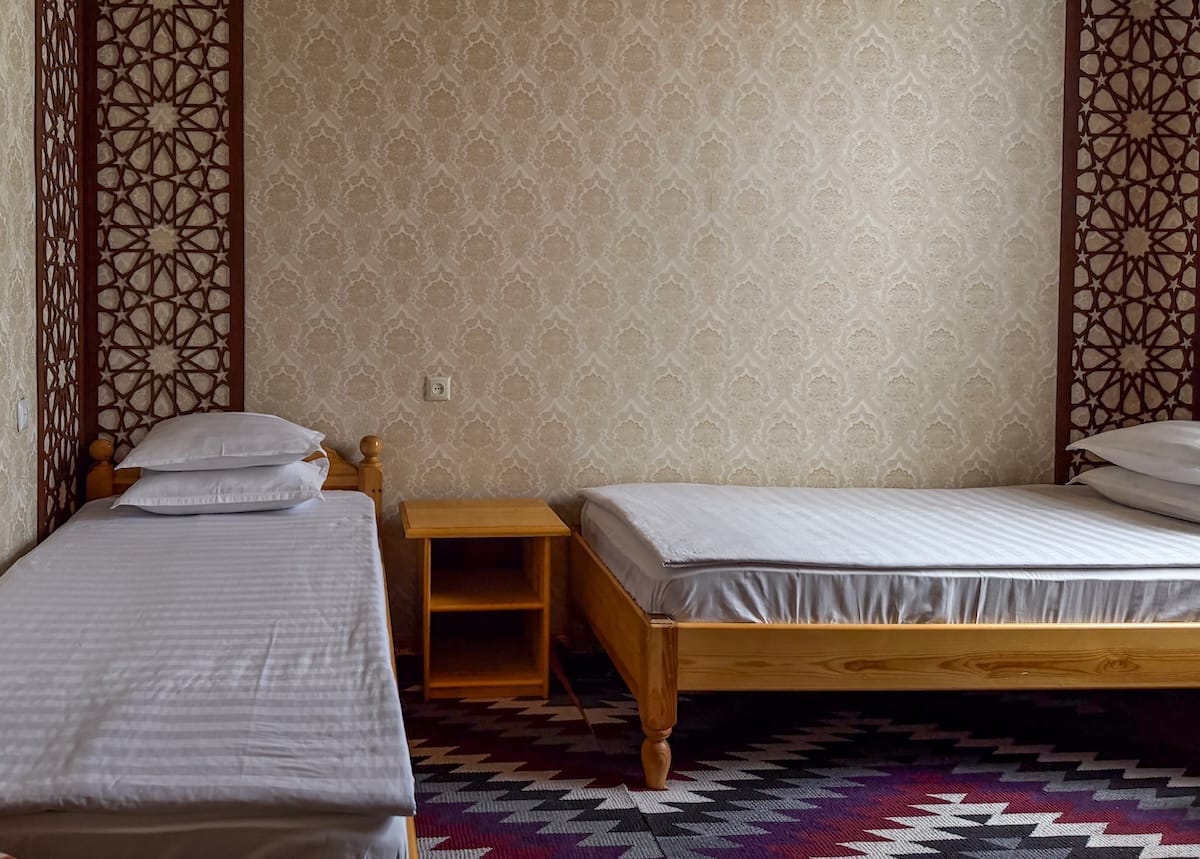 two twin size beds in a room with a colorful carpet
