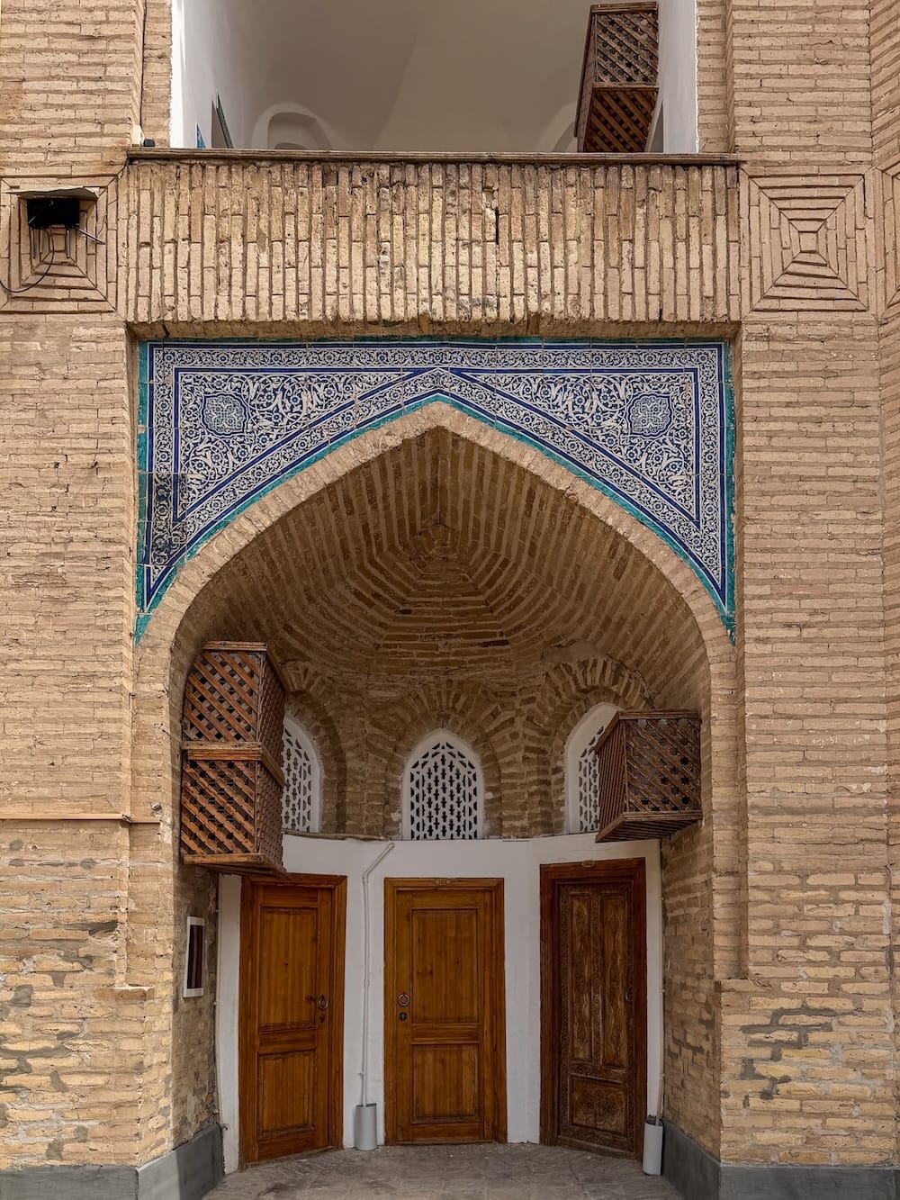 three rooms with doors side by side in a madrasah turned hotel in uzbekistan