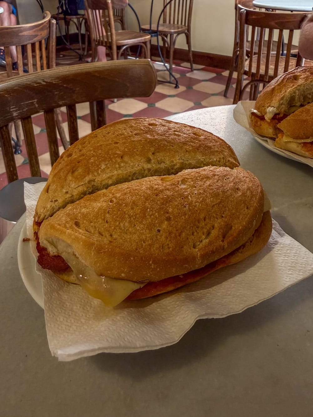 a crispy sandwich on a plate with cheese, sobrasada, and honey