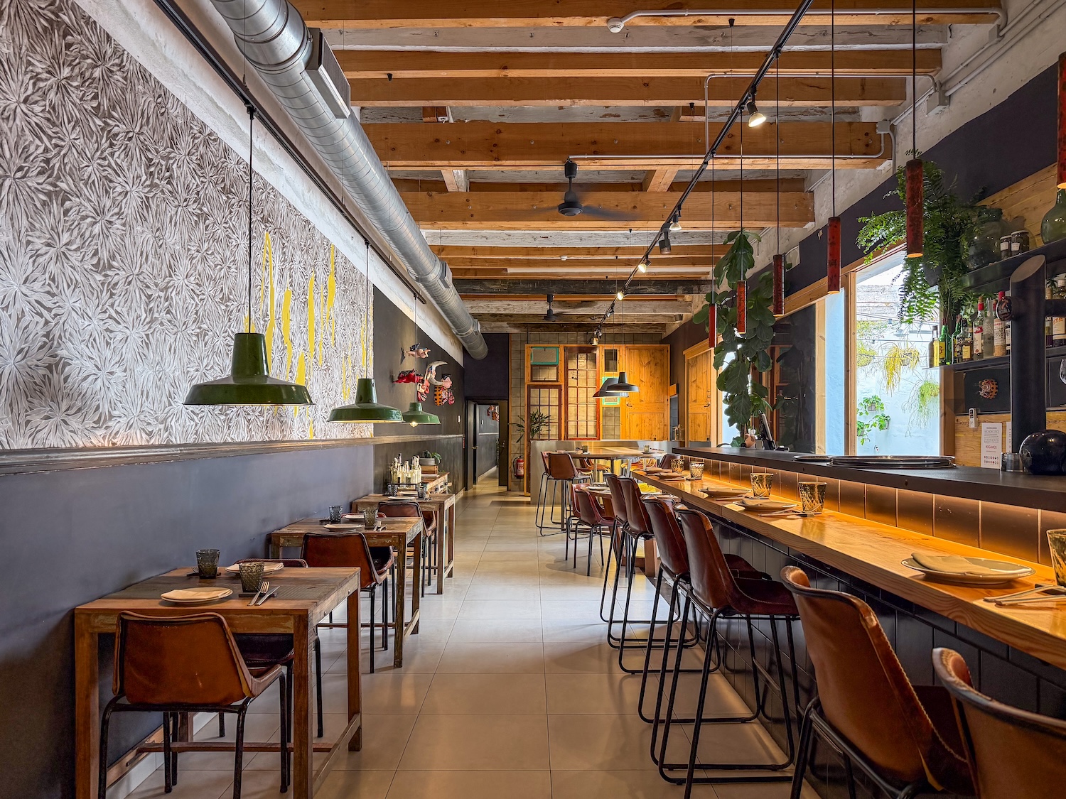 a pretty restaurant with an open bar area leading to a kitchen