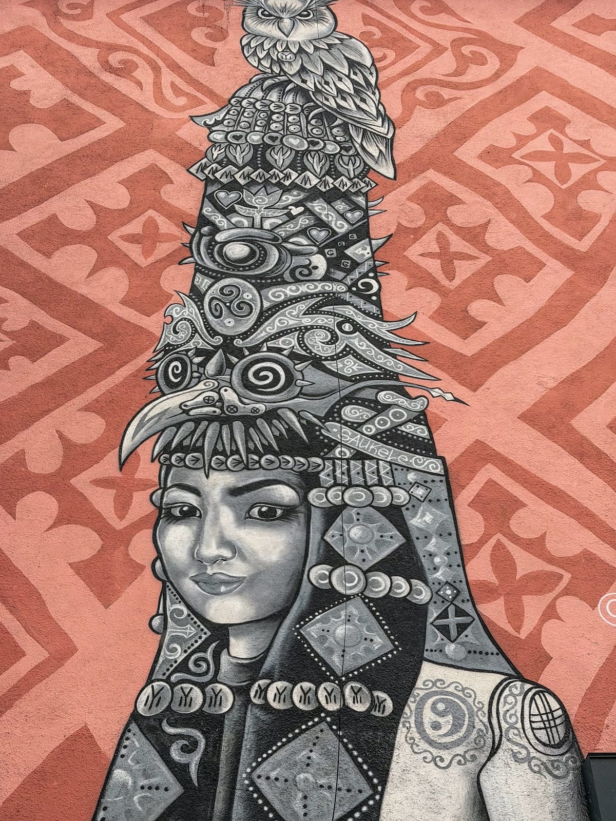 a peach colored mural with a girl in a saukele in kazakhstan