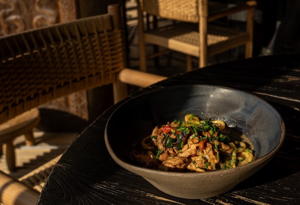 a plate of handpulled noodles on a table in a shadow