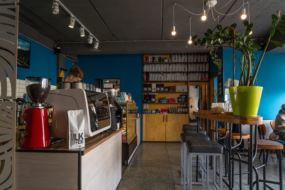 inside a colorful coffee shop with a man standing at a machine