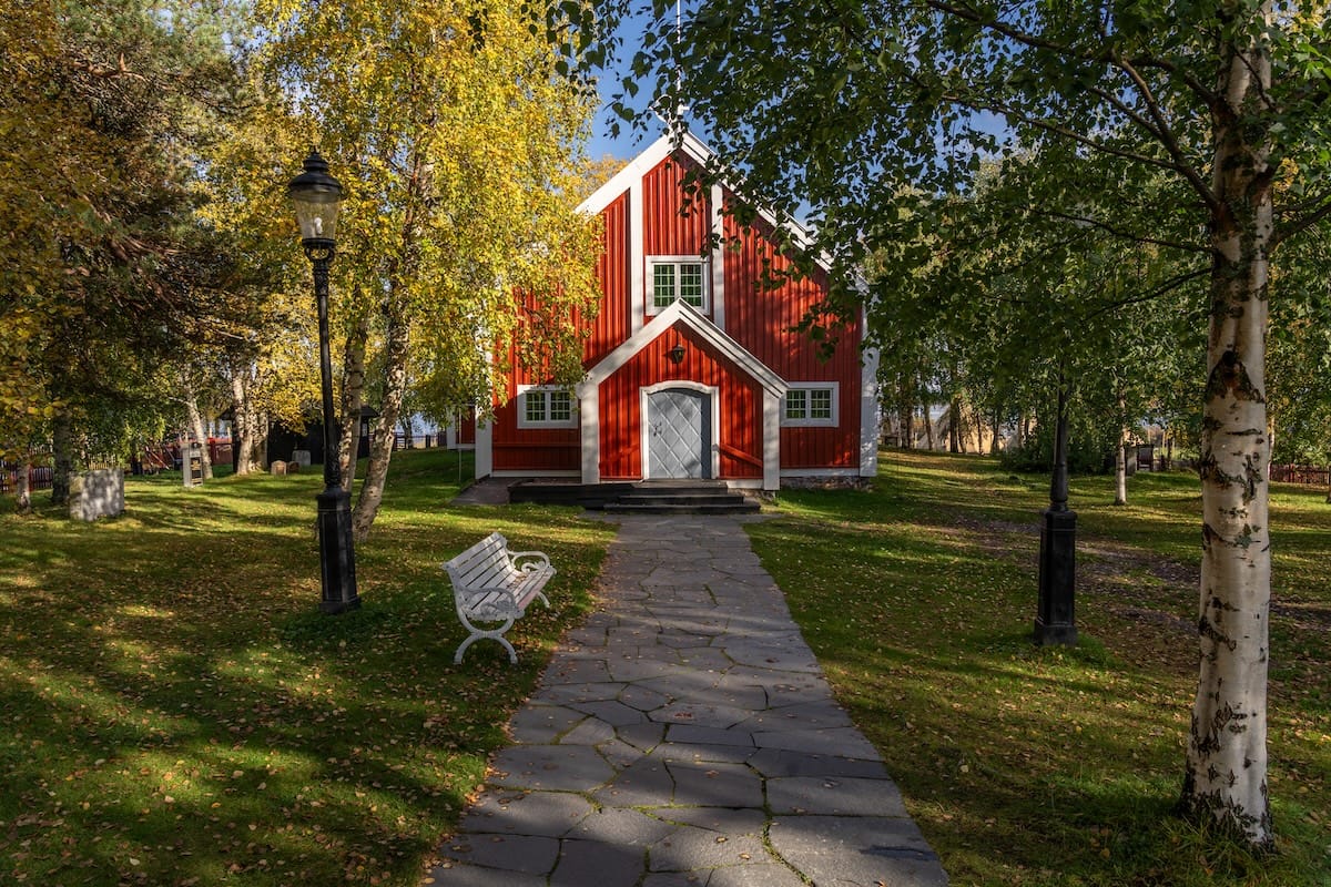 Jukkasjärvi Church

a red church in sweden in the middle of an autumn forest