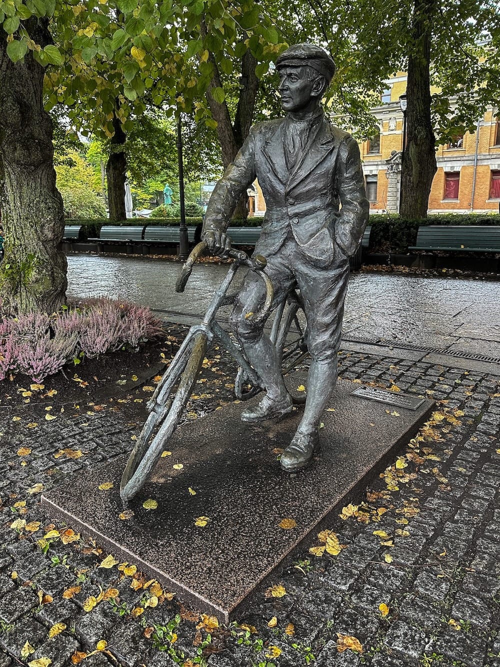 a statue of a guy on a bike on a city street