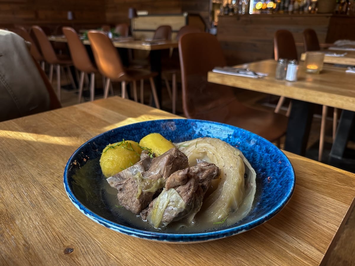 a dish with lamb and cabbage in it on a table