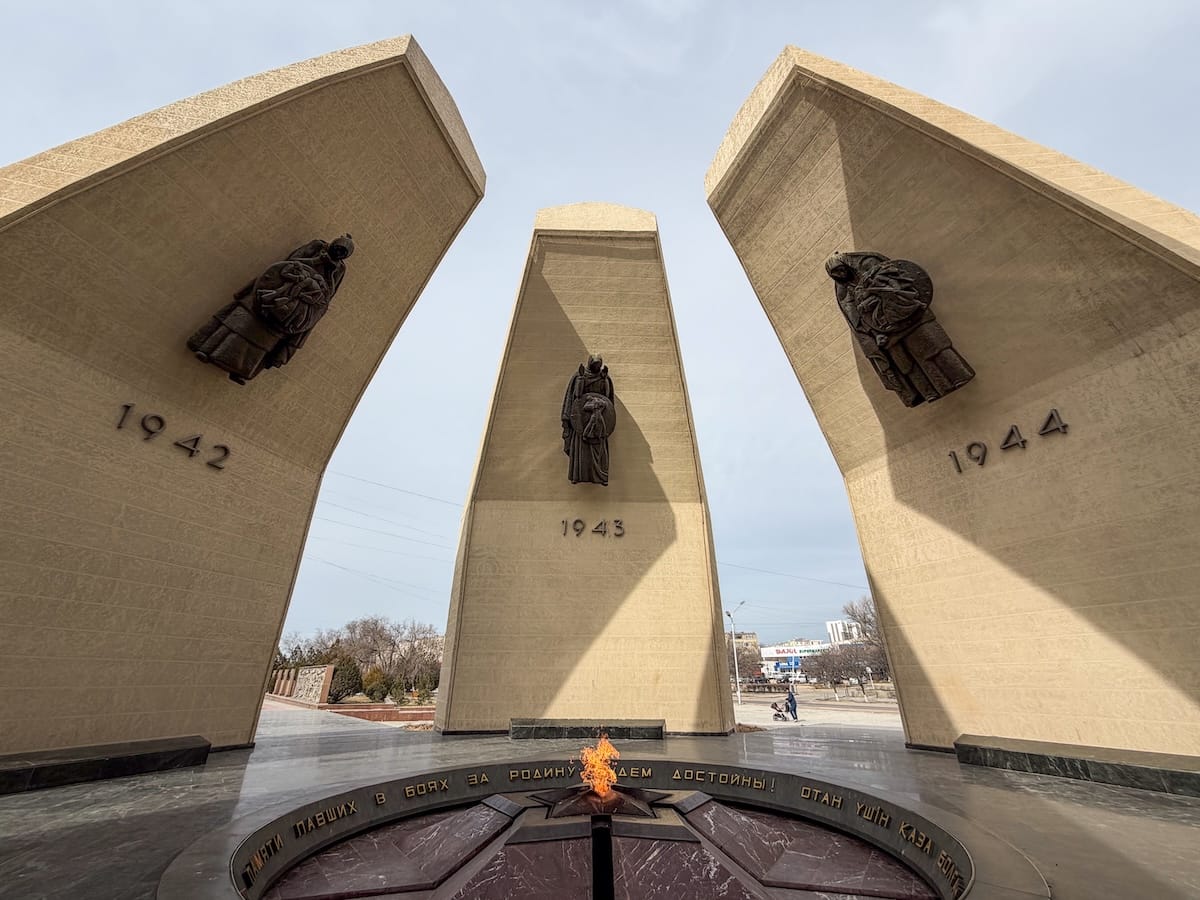 an eternal flame in aktau with large pillars opening on all sides of it