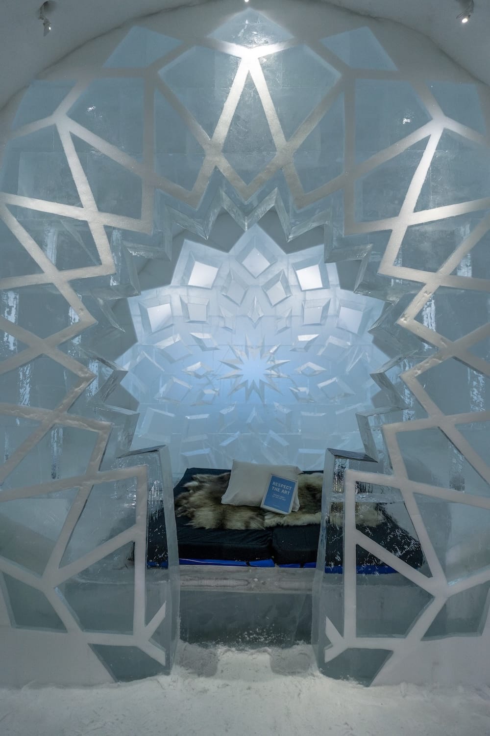 inside a room made of ice in sweden with a bed in the middle