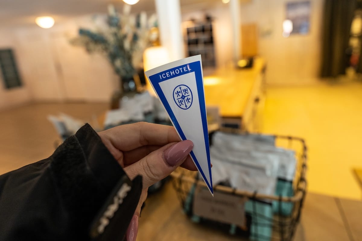 an entrance sticker to an icehotel in sweden in a woman's hand