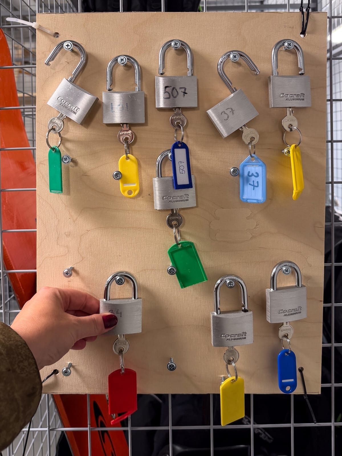 a wall of keys and padlocks with a hand in the photo