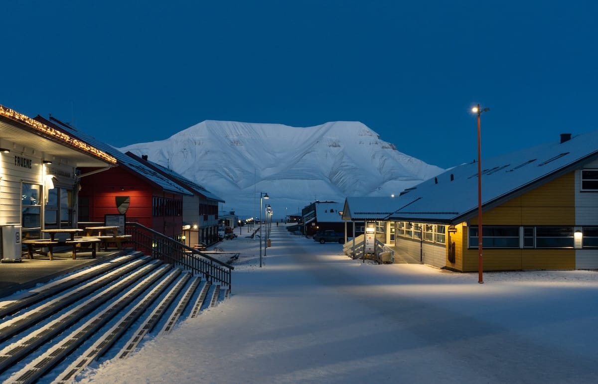 dark blue skies at twilight on a snowy pedestrian way in Svalbard