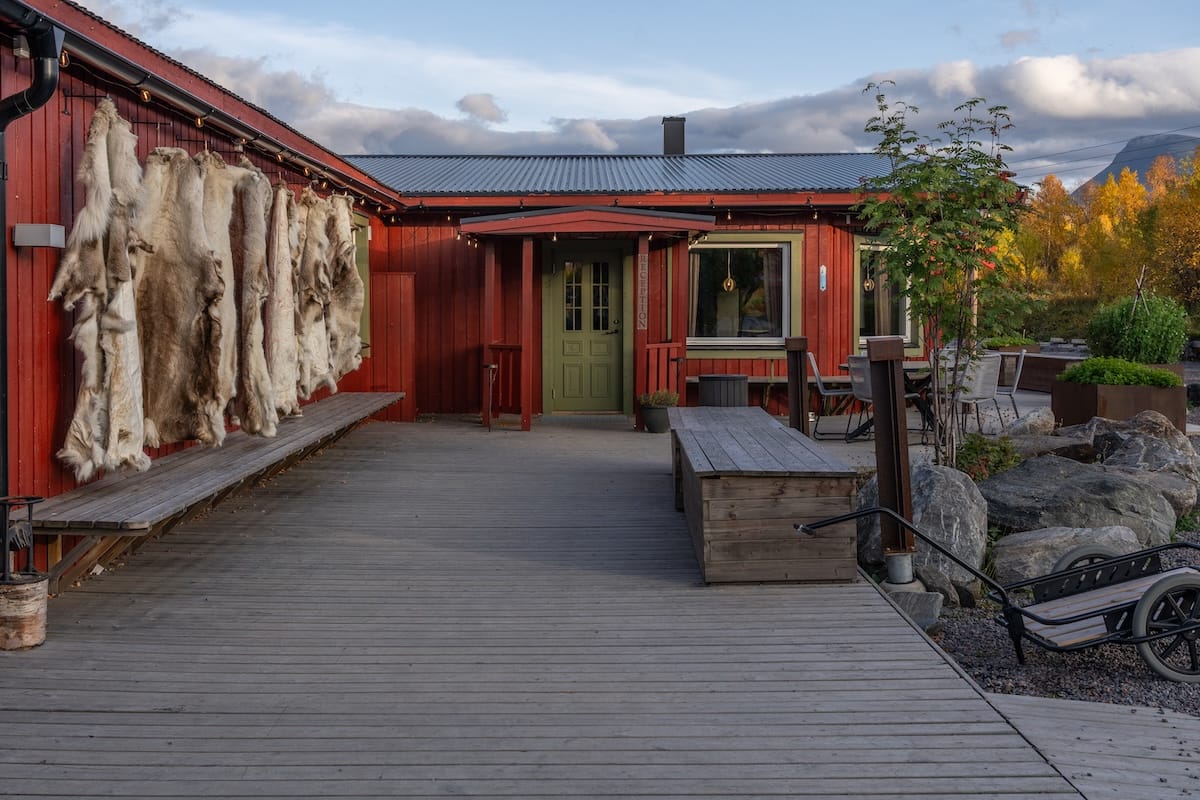 a red building with reindeer skins drying on the outside in sweden