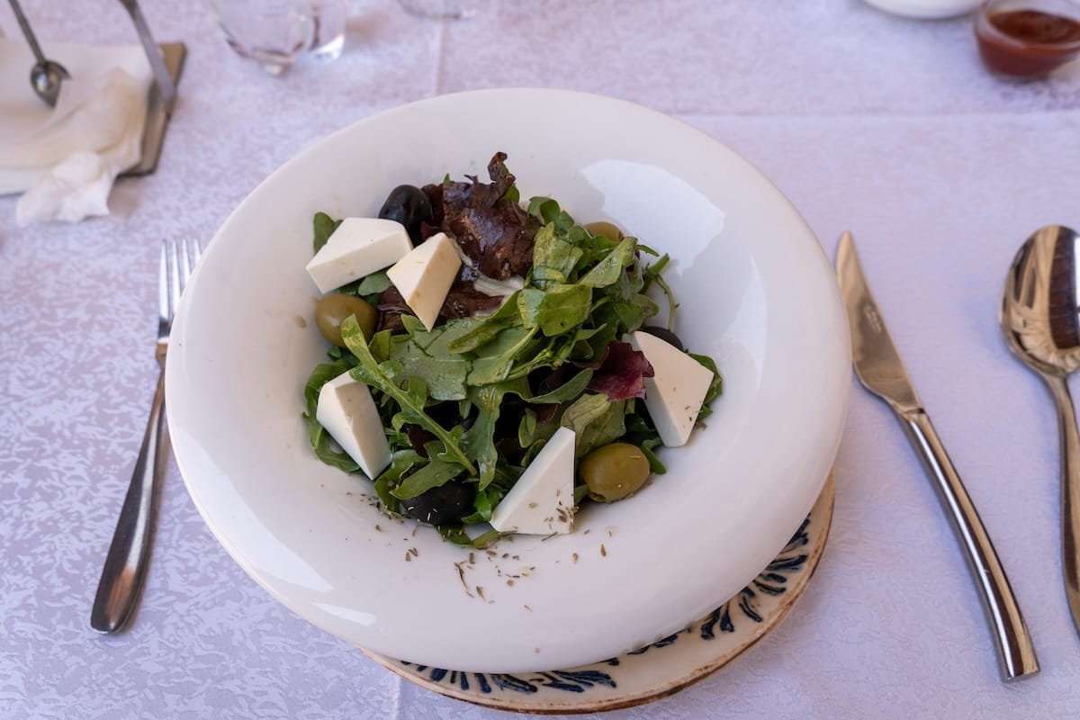 Fresh arugula salad with feta cheese, olives, and pastirma at Ayvan Restaurant in Bukhara, Uzbekistan