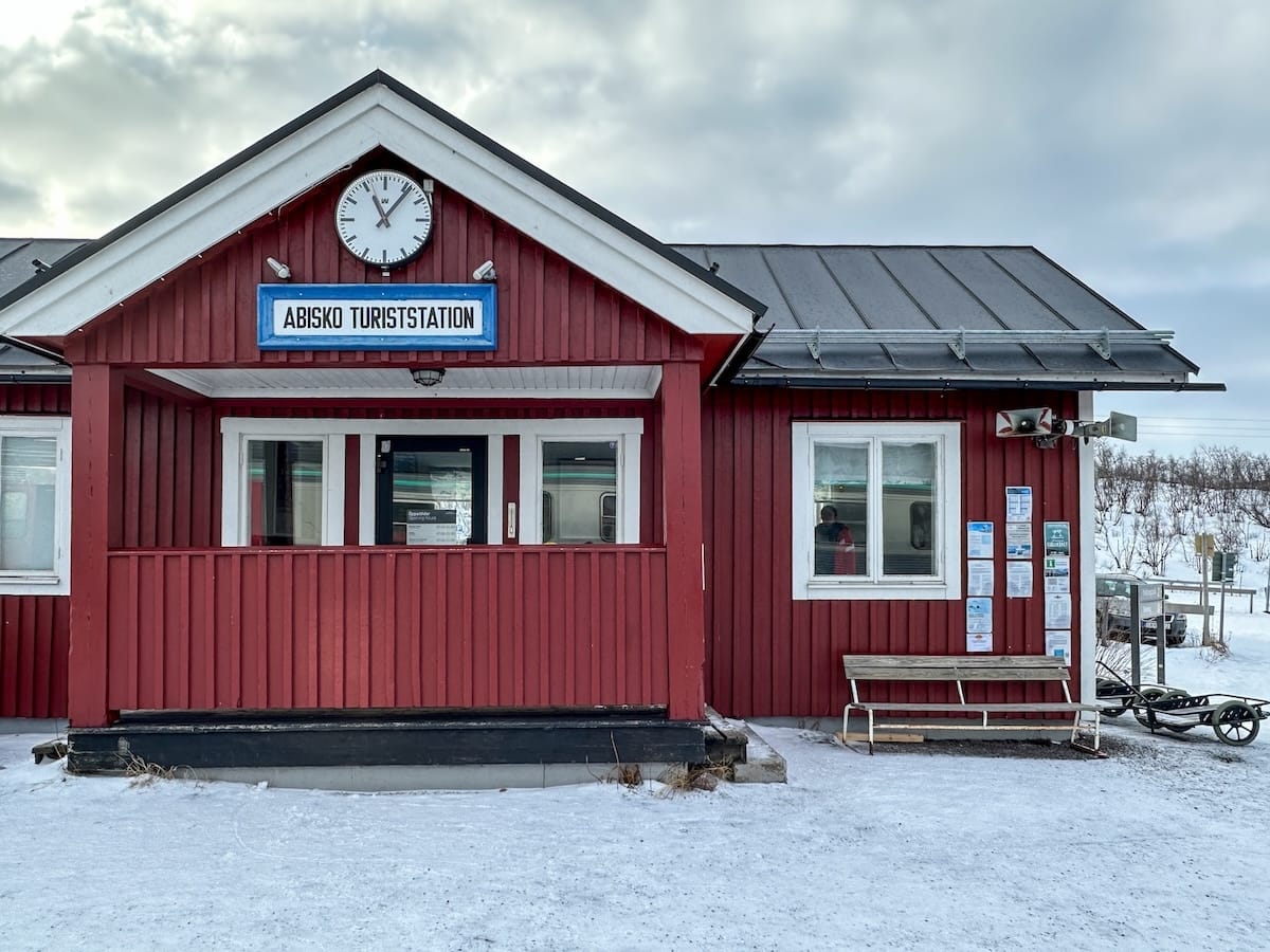 a red wooden building that serves as a train station with a sign that says 'Abisko Turist'