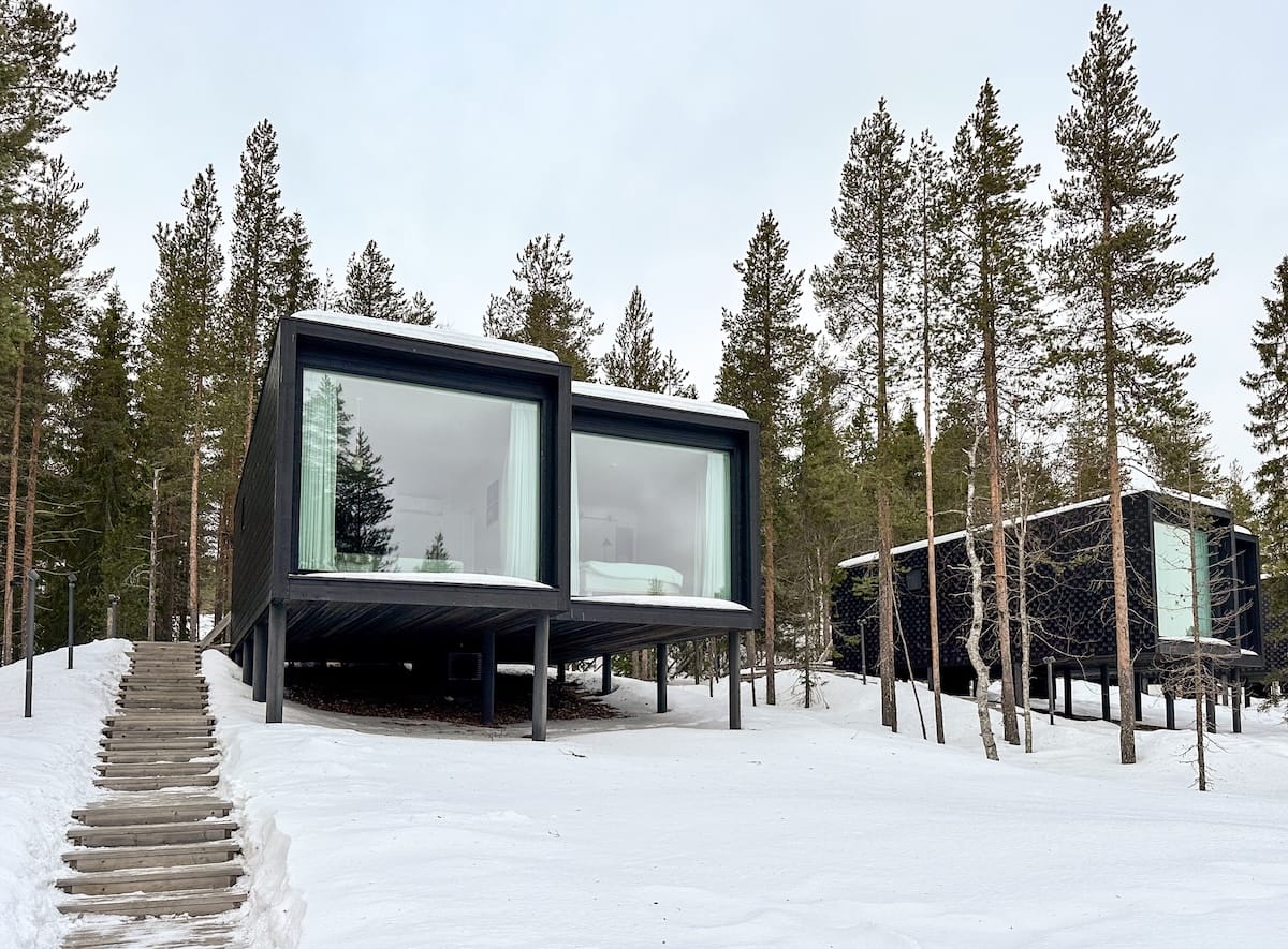 Arctic TreeHouse Hotel from the outside
two lifted cabins at a resort in the snow