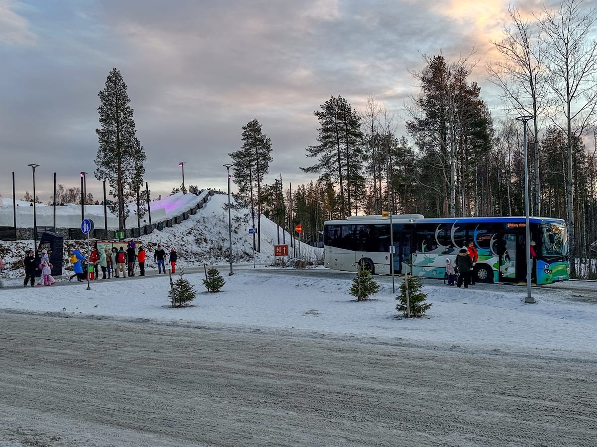 The bus stop at SCV for the #8 bus
a wintery scene with a bus stop and people standing outside of it