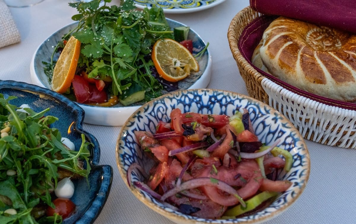 Spread of fresh salads and traditional non bread at Old Bukhara Restaurant in Bukhara, Uzbekistan