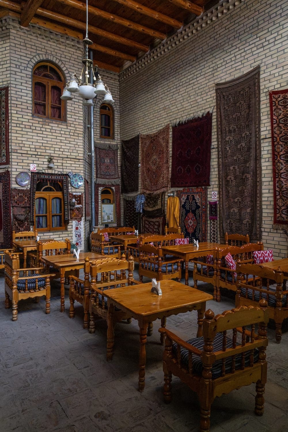Interior of Silk Road Teahouse in Bukhara
a brick interior of a teahouse with a lot of uzbek textiles decorating it