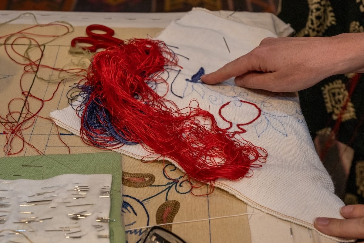 Getting started at my suzani workshop in Bukhara
a woman's hand showing how to do a craft with a long bundle of thread