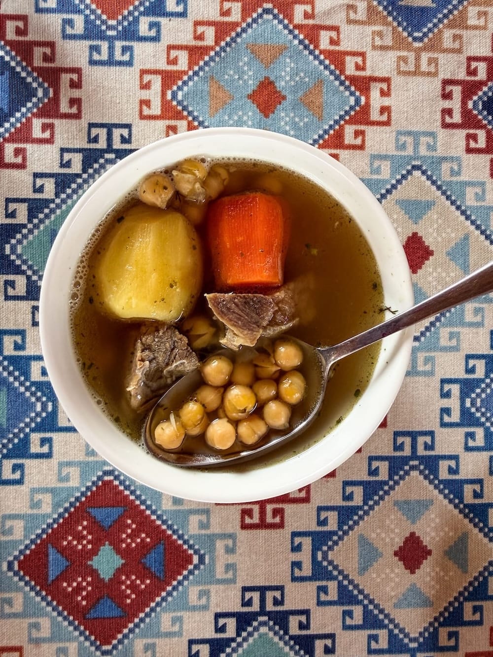 Bowl of balaza soup with beef, potato, and chickpeas at Xon Atlas restaurant in Bukhara, Uzbekistan