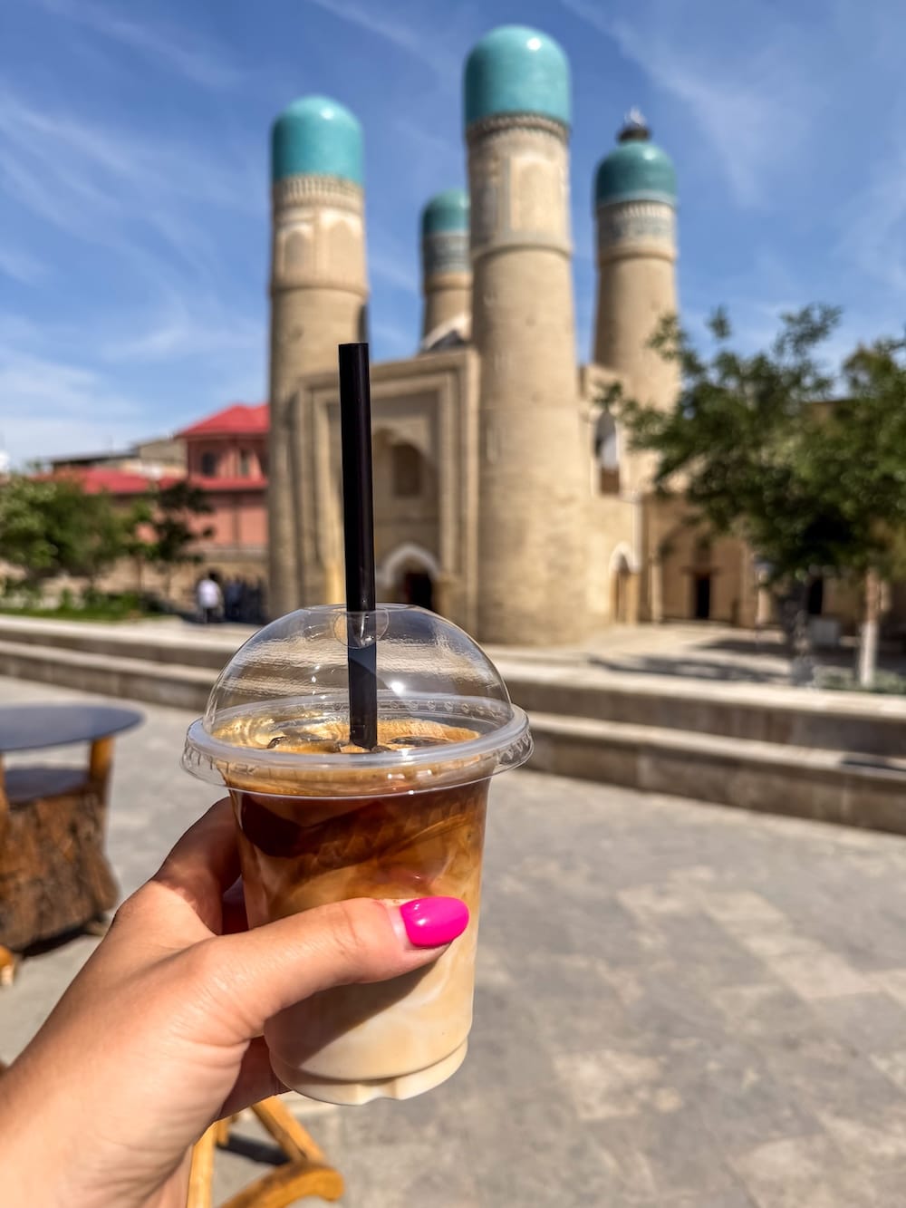 My iced latte (and Chor Minor) at coffeeFi
a monument in uzbekistan with a woman's hand and an iced coffee in it