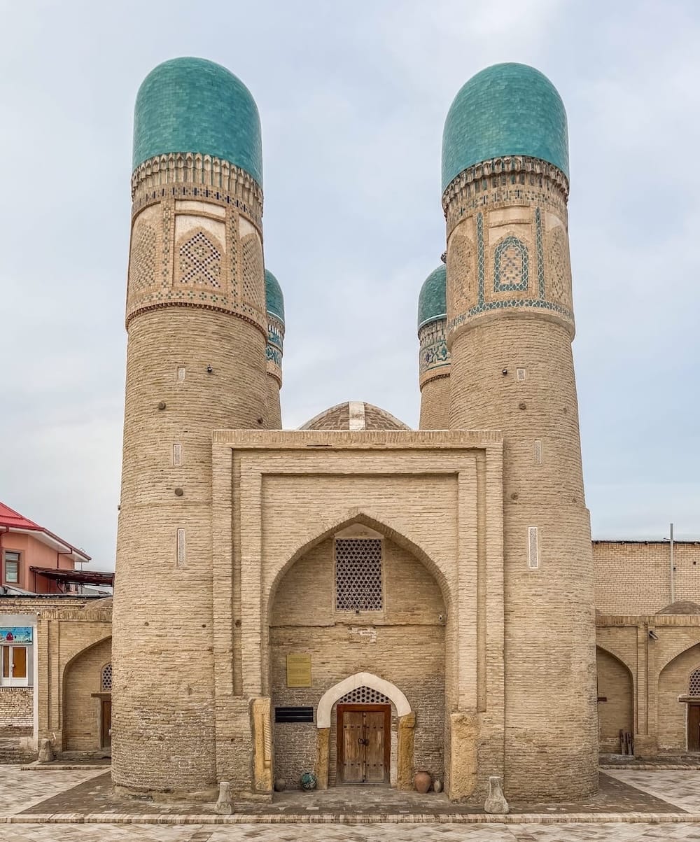 Chor Minor's four turquoise-domed towers rising above its arched entrance in Bukhara, Uzbekistan