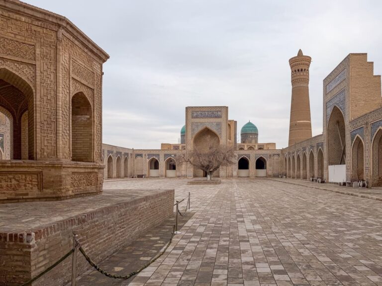 Bukhara in winter (the empty Kalan Mosque) Empty courtyard of the Kalyan Mosque in Bukhara with the Kalyan Minaret, turquoise domes, and carved brick arcades under an overcast winter sky
