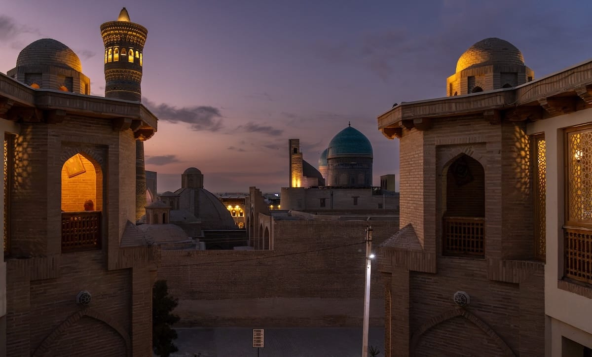 Twilight view of the Kalyan Minaret and turquoise domes from Minorai Kalon Restaurant and Terrace in Bukhara, Uzbekistan