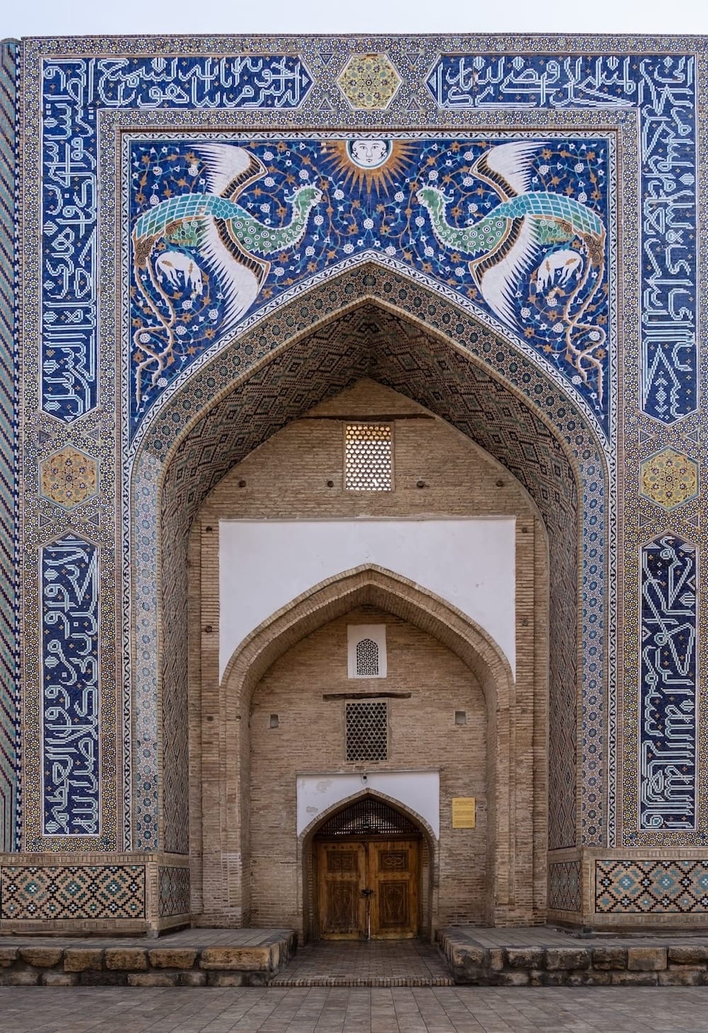Ornate portal of the Nadir Divan-Begi Khanaka with mythical phoenix tilework and calligraphy, Bukhara, Uzbekistan